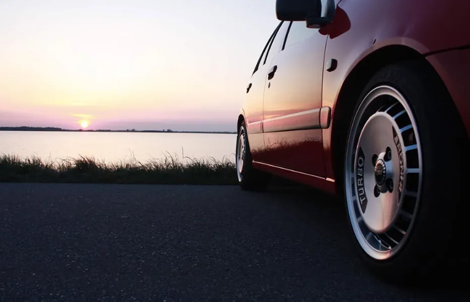 Detalje af bilen ved en sø i aftensolen